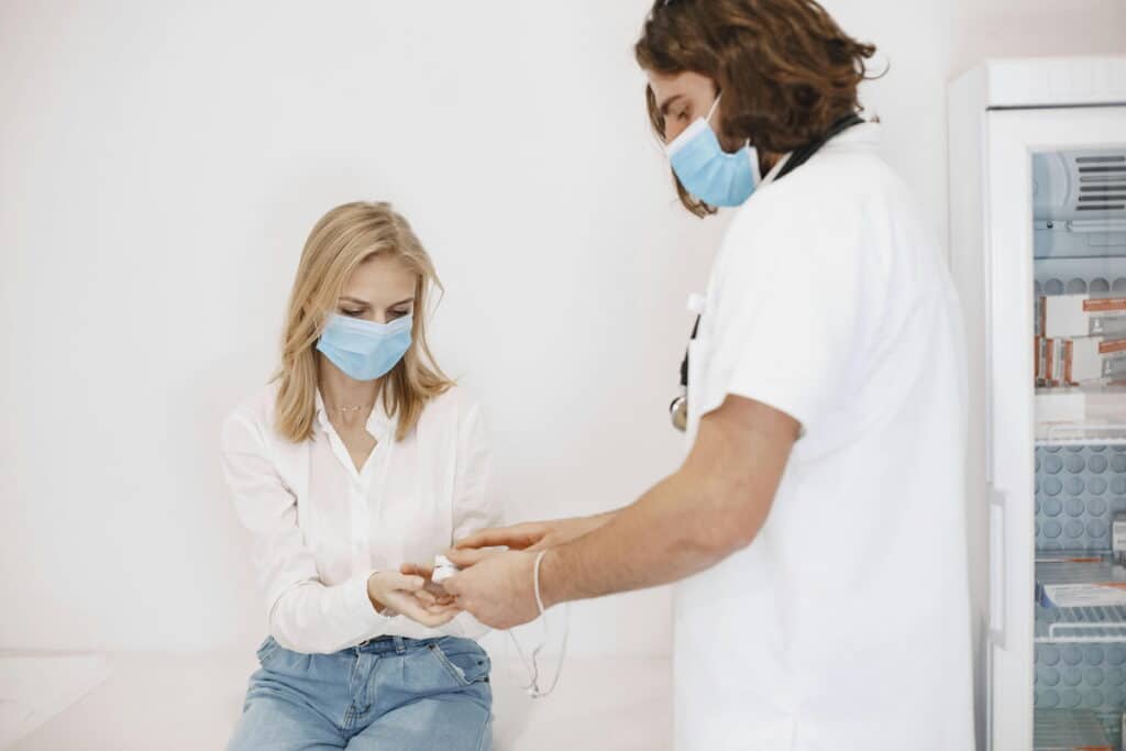 A Woman Wearing a Face Mask Getting a Checkup